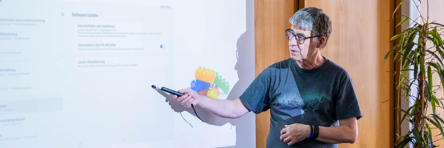 Ein Referent erläutert anhand einer projizierten Computeroberfläche die Durchführung eines Software-Updates.